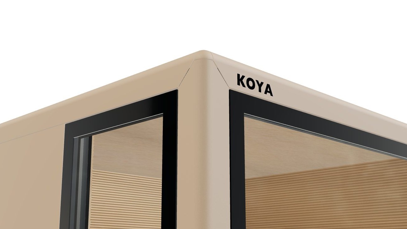 Abgerundete Ecke des Sauna Cube im Beigeton Lehm, schwarzer KOYA-Schriftzug und schwarz gerahmtes Glas