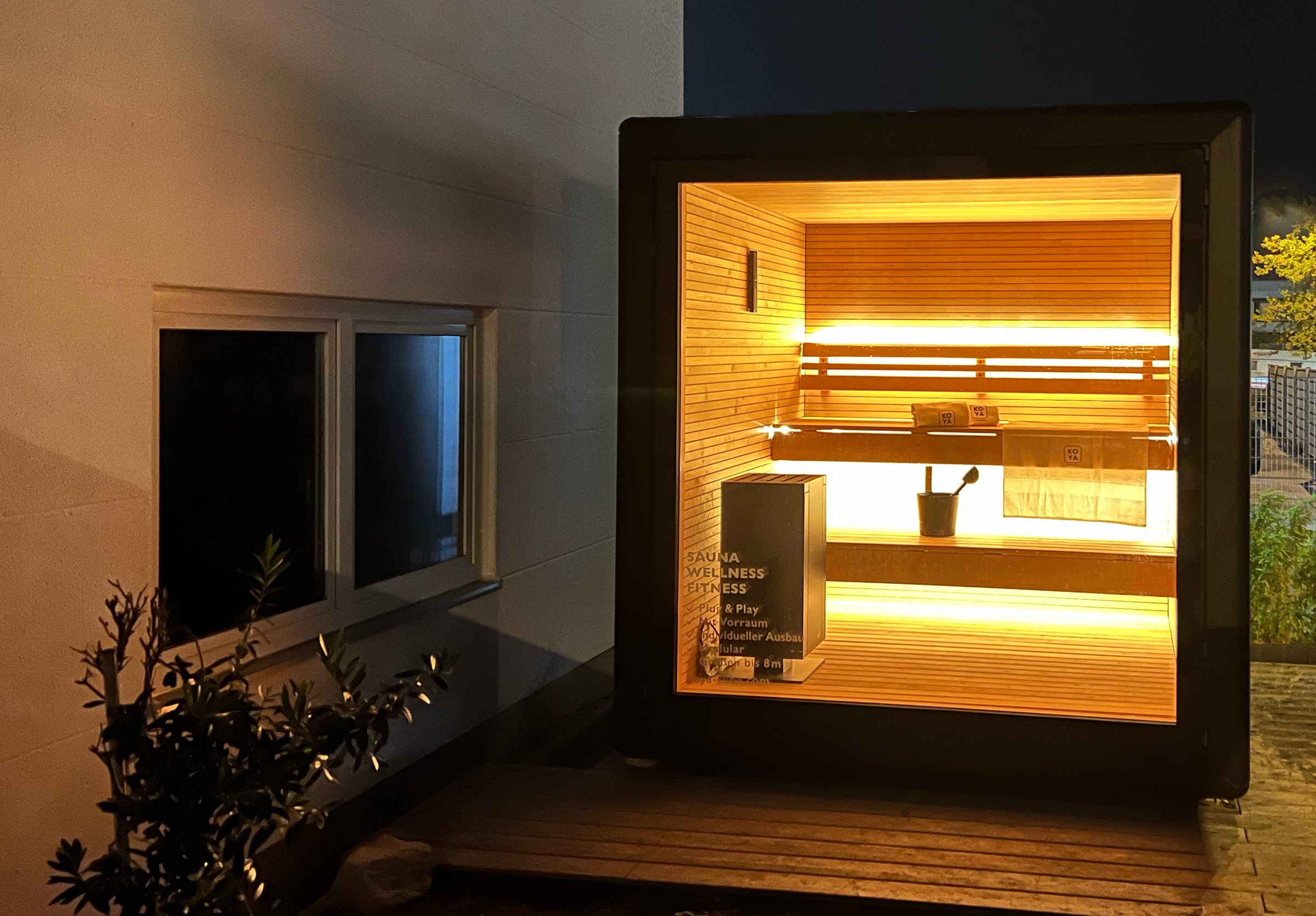 KOYA Sauna Cube bei Nacht, innen warm beleuchtet